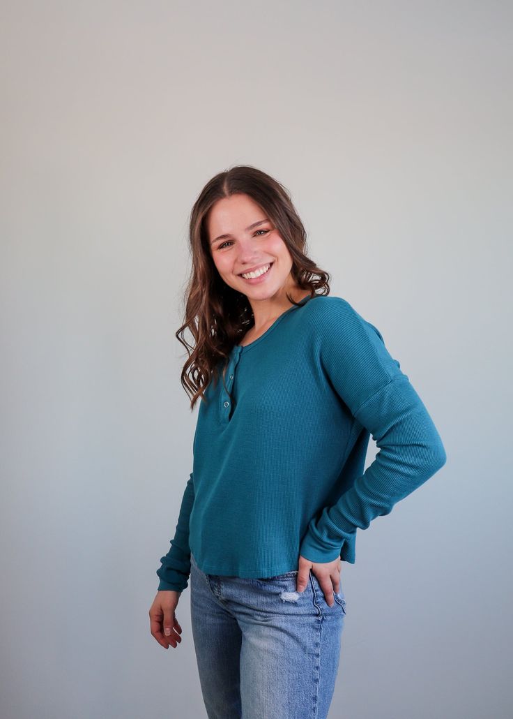 This henley long-sleeve tee from Bobi is the perfect comfortable, yet stylish basic to add to your capsule wardrobe. It features a soft, waffle knit fabric, drop shoulders, snap buttons by the neckline, and a cropped hem that sits right at the top of the hips. Pair with your favorite jeans and sneakers. Details: 56% cotton, 40% modal, 4% spandex Machine washable TTS Henley Tee, Small Tops, Waffle Knit, Favorite Jeans, Capsule Wardrobe, Drop Shoulder, Knit Fabric, Knitted Fabric, Long Sleeve Tees