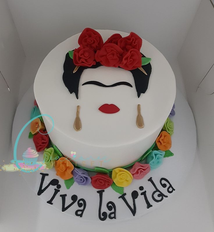 a white cake decorated with flowers and an image of a frida lavidda