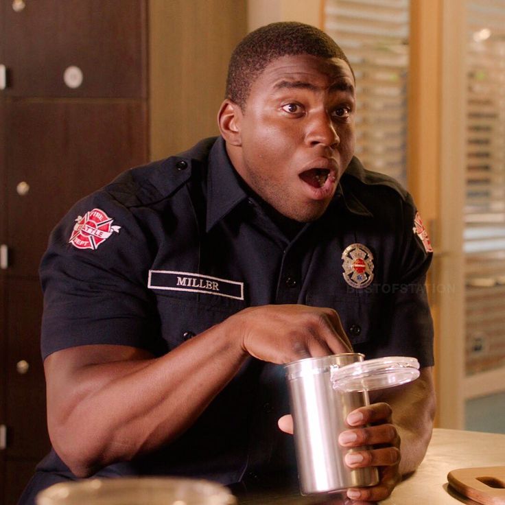 a man in uniform holding a cup and making a face