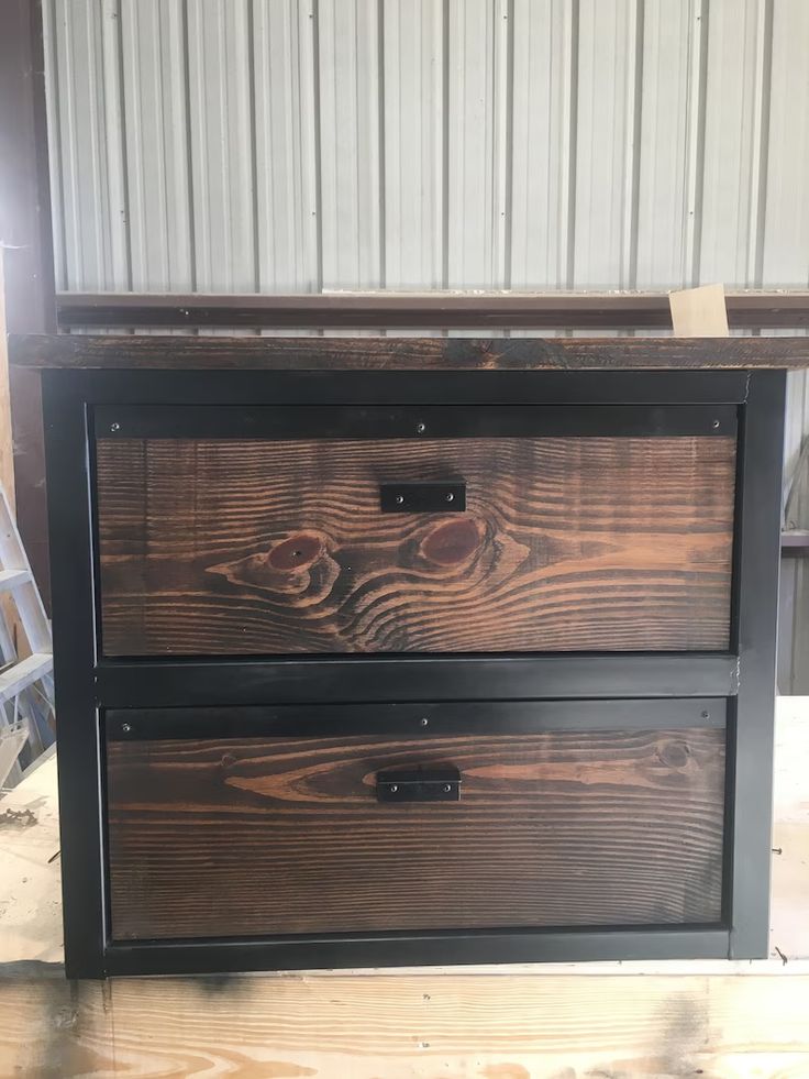 two drawers are stacked on top of each other in the process of being painted black