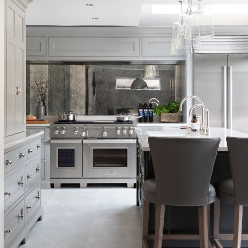 a kitchen with white cabinets and gray countertops is seen from the doorway to the dining room