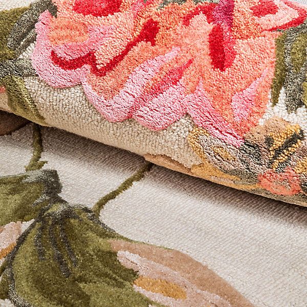 a close up of a pillow on a bed with flowers painted on the back and sides