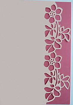 a pink and white card with paper cut outs in the shape of flowers on it