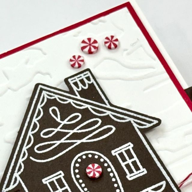 a close up of a christmas card with a gingerbread house and candy canes