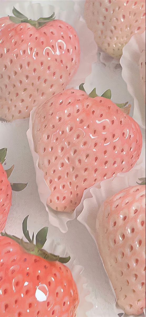 some pink strawberries are laying on top of each other in plastic wrappers and ready to be eaten