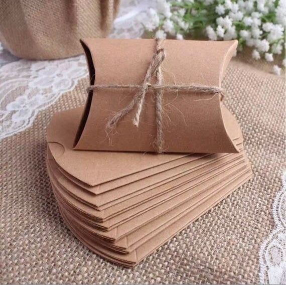 small brown paper bags tied with twine on top of burlocked tablecloth