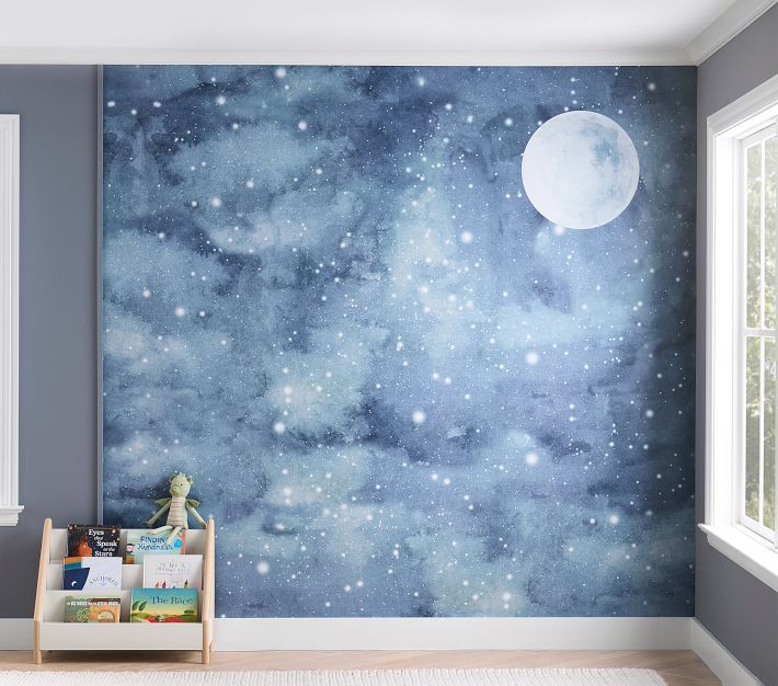 a child's room with a blue and white wallpaper that has stars in the sky