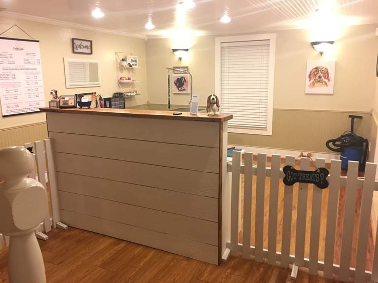 a dog kennel with a wooden floor and white fence