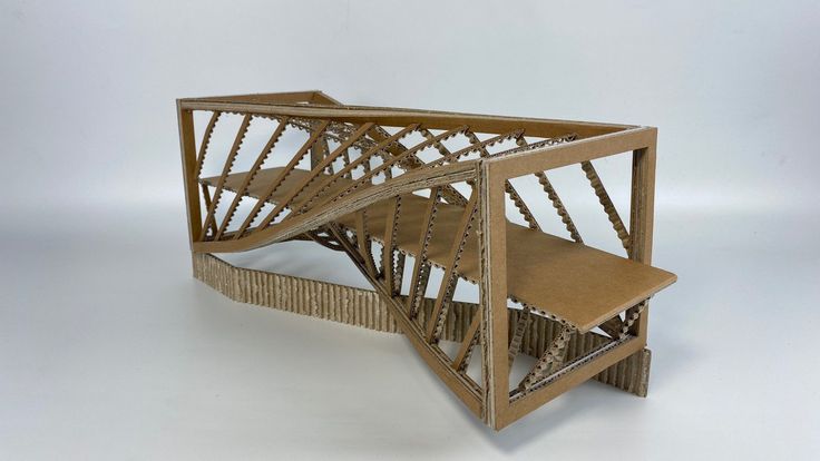 a model of a bridge made out of cardboard on a white surface with no people around it