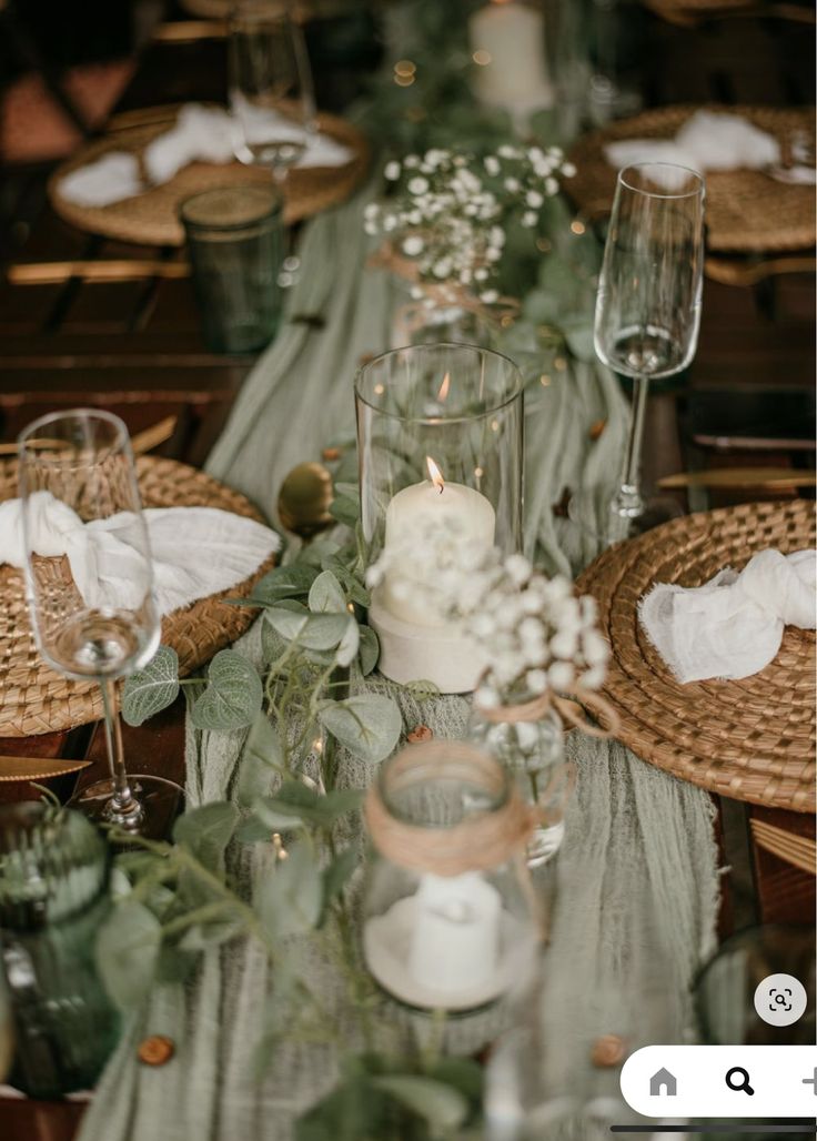 the table is set with candles, plates and napkins for dinner guests to enjoy