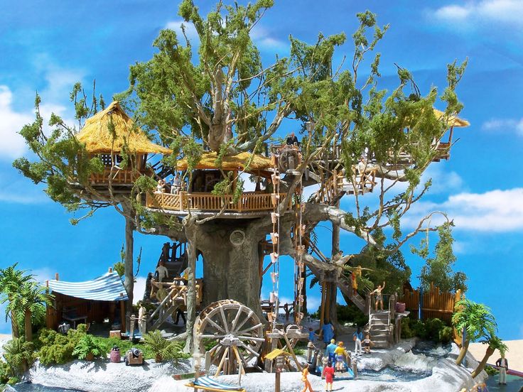 a miniature tree house on an island in the middle of the ocean with people inside