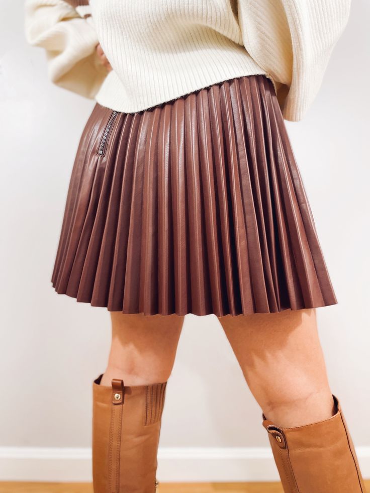 Take your Fall fashion to the next level in our She’s the One Faux Leather Pleated Skirt! The quality of this skirt will leave you swooning and the color alone is jaw dropping. Designed in an a-line silhouette finished with pleats all around and a back zip closure. Pair this with a chunky sweater for an office look or a fitted bodysuit for a night out with the girls. Styled with our Give them Stripes Brown + Cream Balloon Sleeve Sweater Fit: True to size Fabric: 50% Polyester, 50% Polyurethane L Pleated Brown Skirt, Faux Leather Pleated Skirt, Fitted Bodysuit, Balloon Sleeve Sweater, Leather Pleated Skirt, Brown Skirt, Casual Tanks, Brown Skirts, Sweater Fits