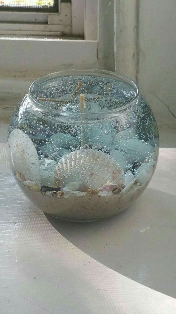 a glass bowl filled with water and sea shells