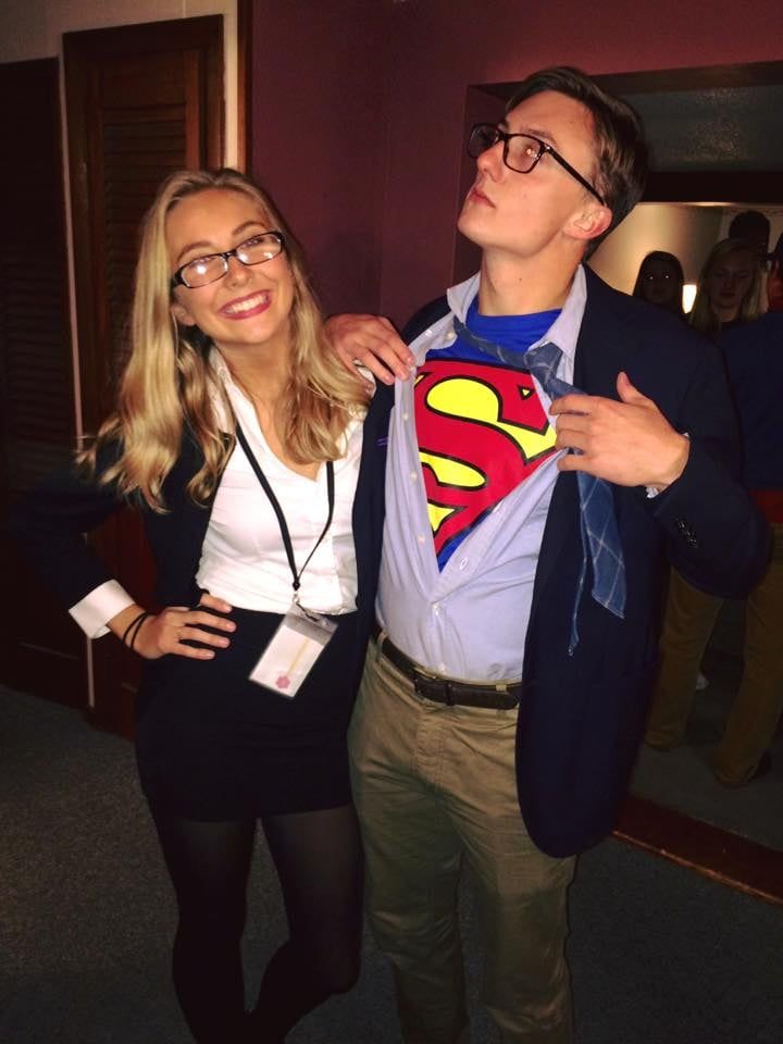 a man standing next to a woman wearing a superman shirt