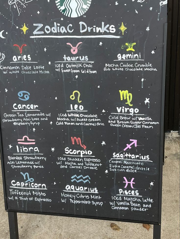 the zodiac drinks menu is written on a blackboard with white writing and colorful symbols