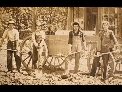 an old black and white photo of men working in the dirt with two horses pulling a wagon