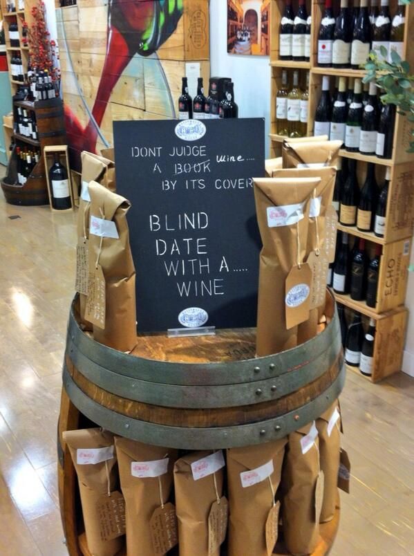 a display in a wine store filled with lots of bottles and bags on top of wooden barrels