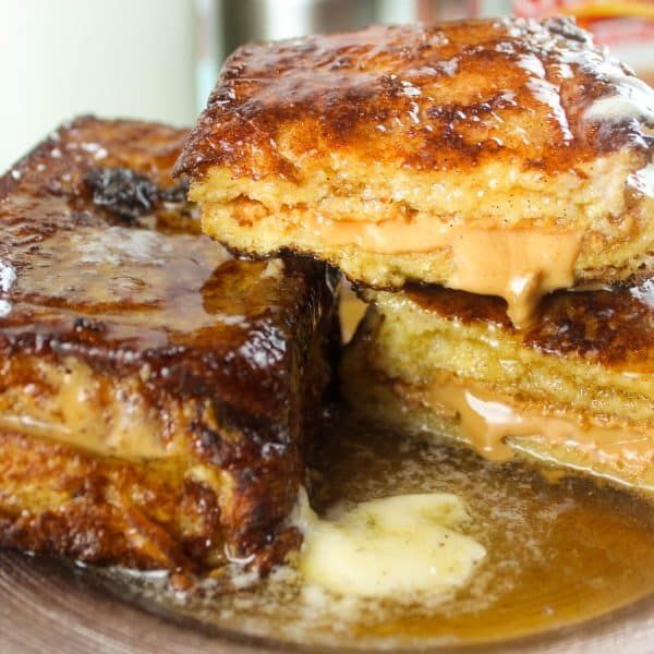 two pieces of french toast sitting on top of a plate covered in syrup and butter