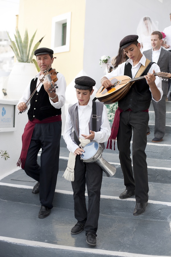 a group of people that are standing on some steps playing musical instruments and drinking wine