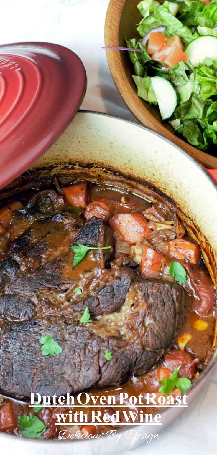 steak and vegetables in a pot next to a bowl of salad