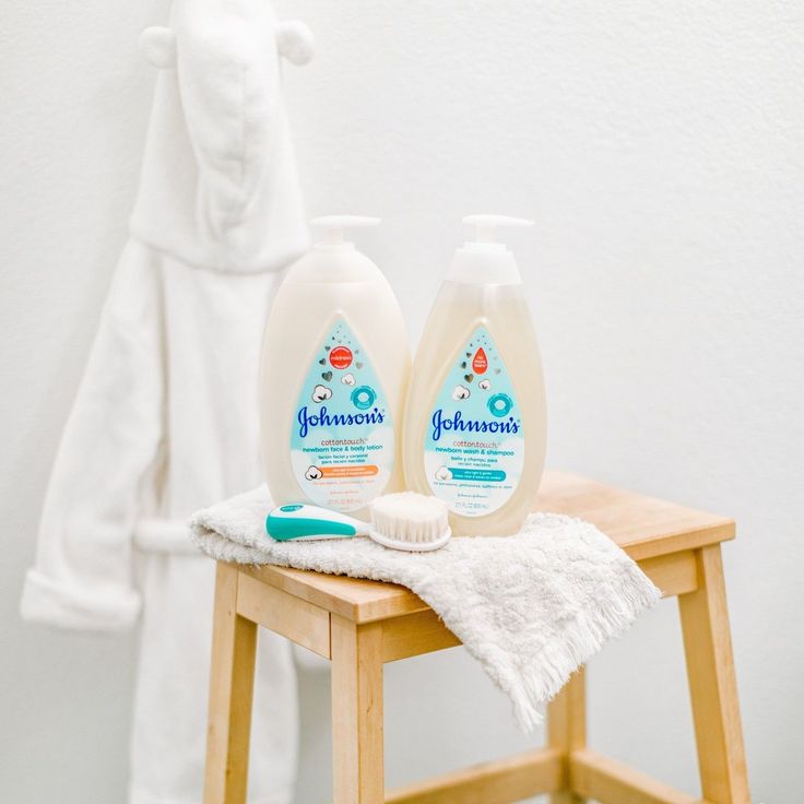 two bottles of johnson's hand sanitizer sitting on a table next to a towel