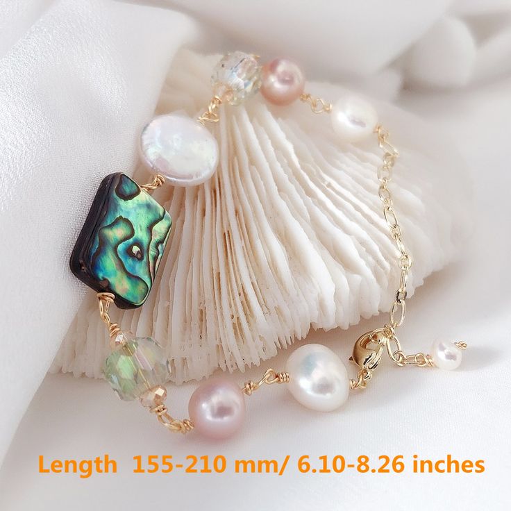 This beautiful Freshwater pearl bracelet is made of 9-10mm big pearls and a piece of natural black mother of pearl - the Abalone Shell. All pearls in this bracelet are near round and are strung with the silk thread of each pearl. Known as the "mother of pearl", the colorful black piece is made of beautiful natural Abelone shell. Huge Tomato imports these real pearls and mother of pearls from the Freshwater farms of Japan. All of our Freshwater pearl bracelets are made on-site, and our extensive High Luster Pearl Bracelet Gift, Elegant Pearl Bracelet With Round Natural Stones, Elegant Pearl Bracelet With Natural Stones, Elegant Adjustable Mother Of Pearl Bracelet, Gift Pearl Bracelet With High Luster Round Beads, Elegant Pearl Beaded Bracelets With Natural Stones, Gift Pearl Bracelet With High Luster, High Luster Pearl Bracelet With Round Beads As Gift, Elegant Mother Of Pearl Beaded Bracelets As Gift