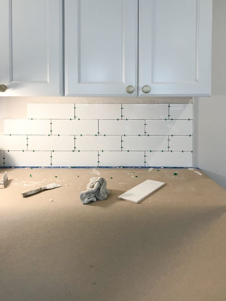 the kitchen counter is being remodeled with white cabinets and construction materials on top of it