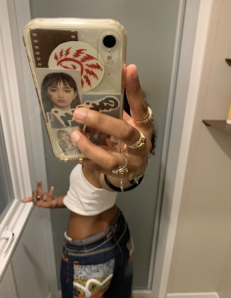 a woman taking a selfie with her cell phone in the bathroom while wearing shorts