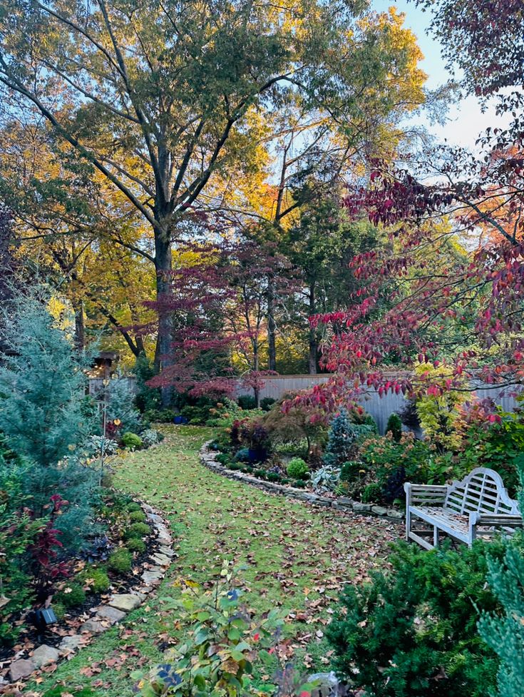 a white bench sitting in the middle of a garden