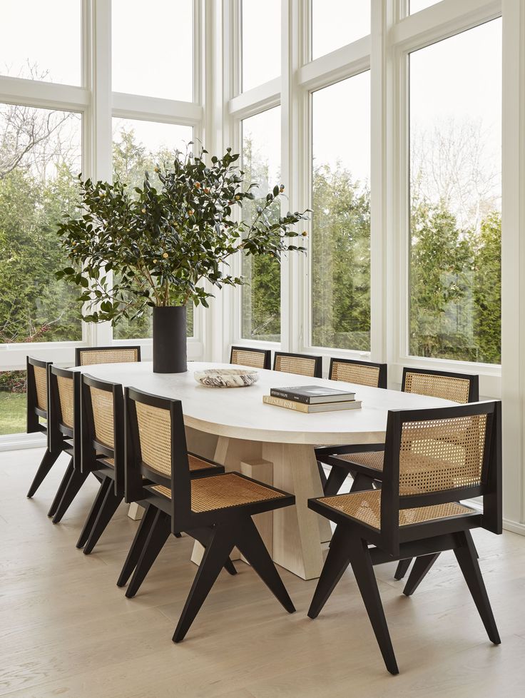 a dining room table with chairs and a vase on it