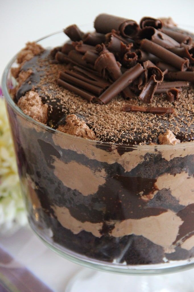 a cake with chocolate frosting and sprinkles in a glass dish on a table