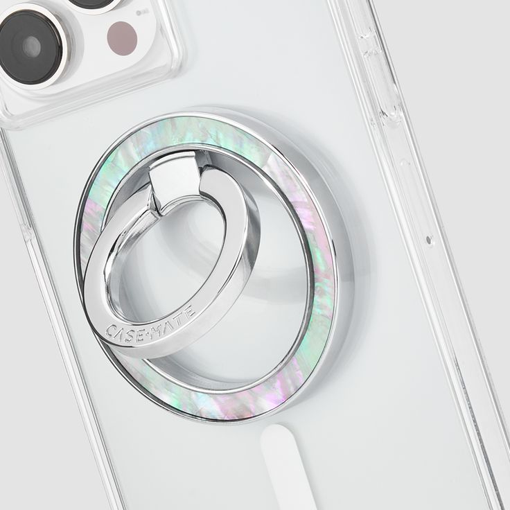 an iphone case with two rings attached to the back of it, sitting on top of a white surface