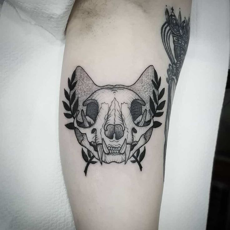 a black and white tattoo with a cat's head in the middle of it