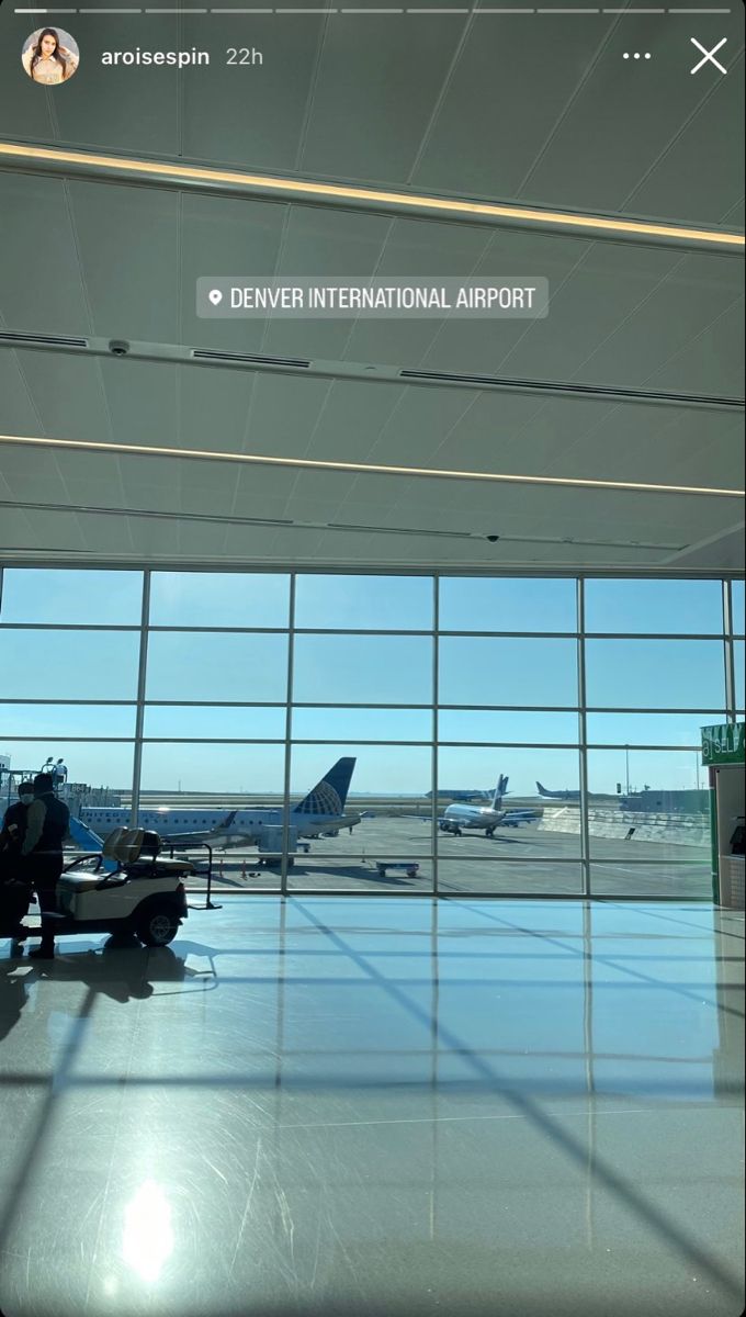 an airport terminal with planes parked in the background