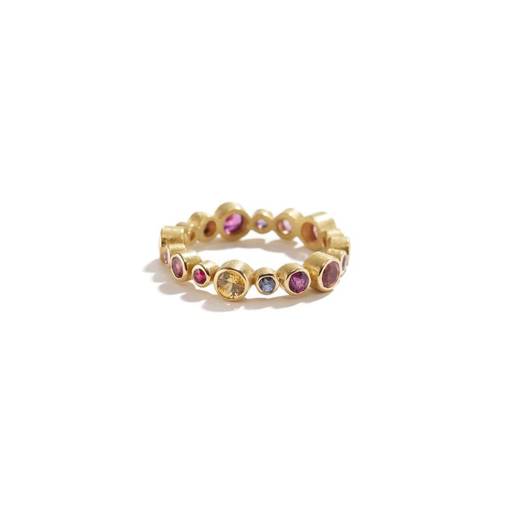 18K yellow gold, round pink and purple sapphires 1.75 ctw, rubies, 0.06 ctw. • Size 6.5 (53.16mm) inside circumference • 0.18" (4.572mm) band width Gold Pink Sapphire Ring With Round Cut, Gold Pink Sapphire Ring In Round Cut, Pink Sapphire Ring In Yellow Gold, Purple Jeweled Round Jewelry, Gold Pink Sapphire Round Ring, Gold Pink Sapphire Birthstone Ring, Fine Jewelry Purple Round Gemstones, Yellow Gold Stackable Rings With Pink Sapphire, Gold Multi-stone Sapphire Ring