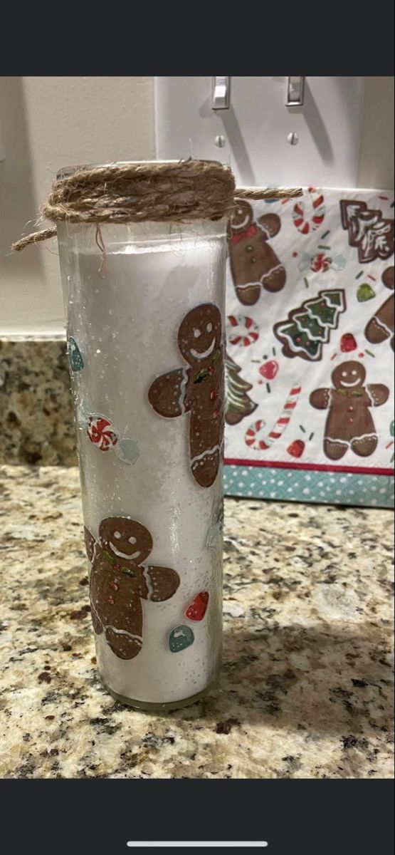 a glass with gingerbreads on it sitting on a counter