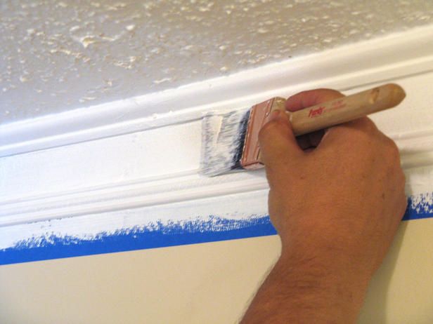 a man is painting the ceiling with blue paint and a brush on top of it