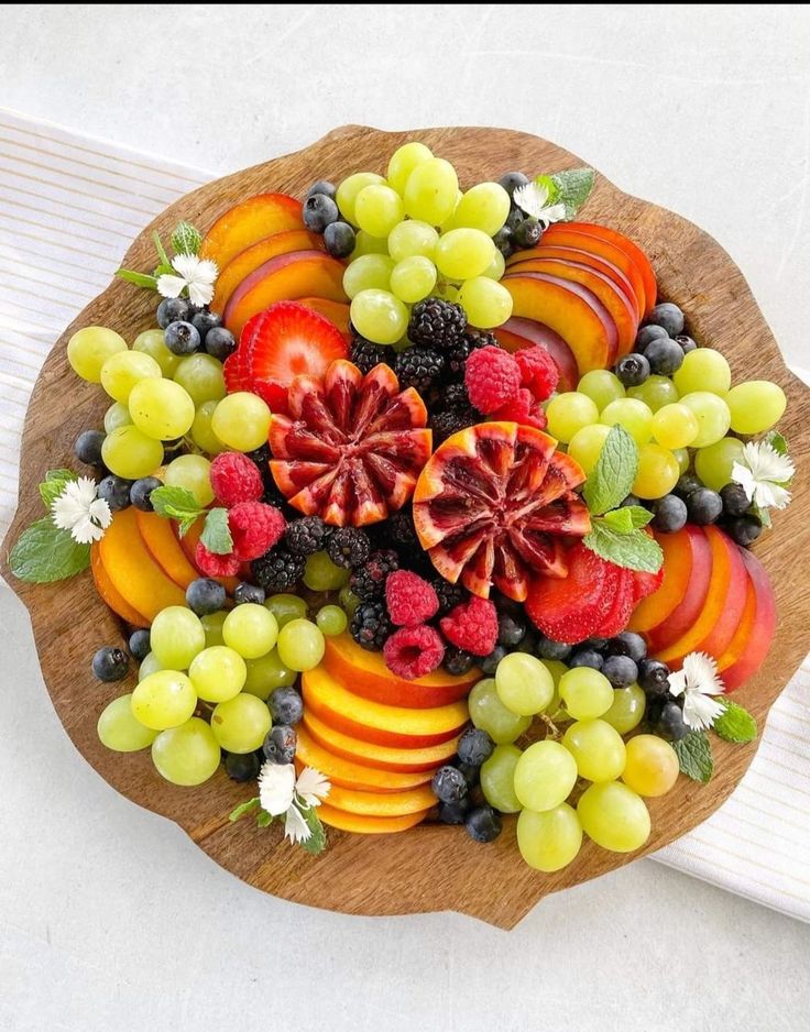 a wooden platter filled with assorted fruit