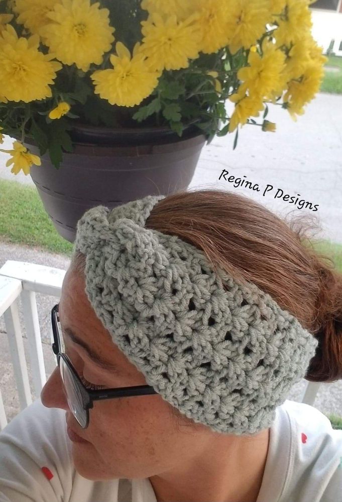 a woman wearing a gray crochet headband next to yellow flowers