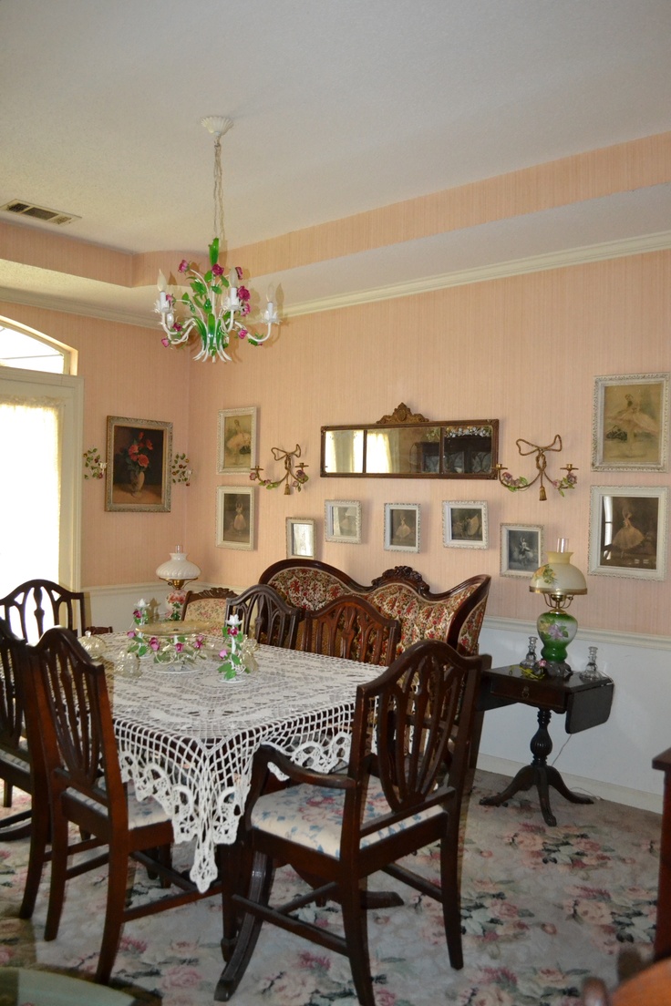 a dinning room table with chairs and a chandelier hanging from the ceiling