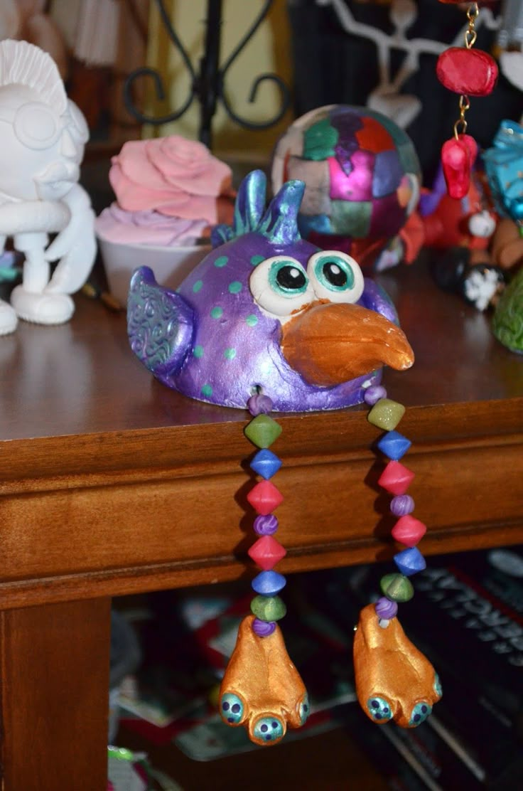 a purple bird is sitting on a table next to other figurines and toys