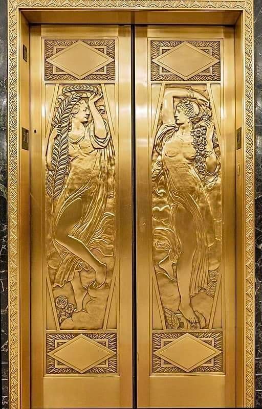 two golden doors with art nouveau designs on them