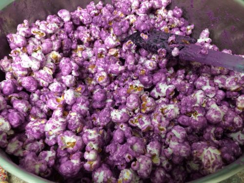 a bowl filled with purple popcorn sitting on top of a table