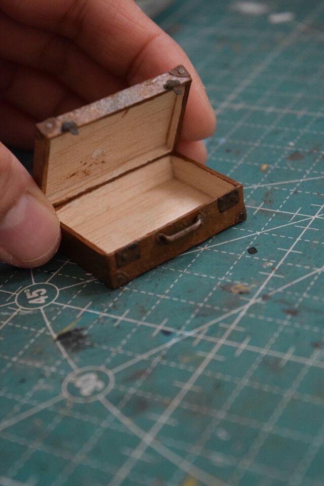 a person holding a small wooden box in their hand