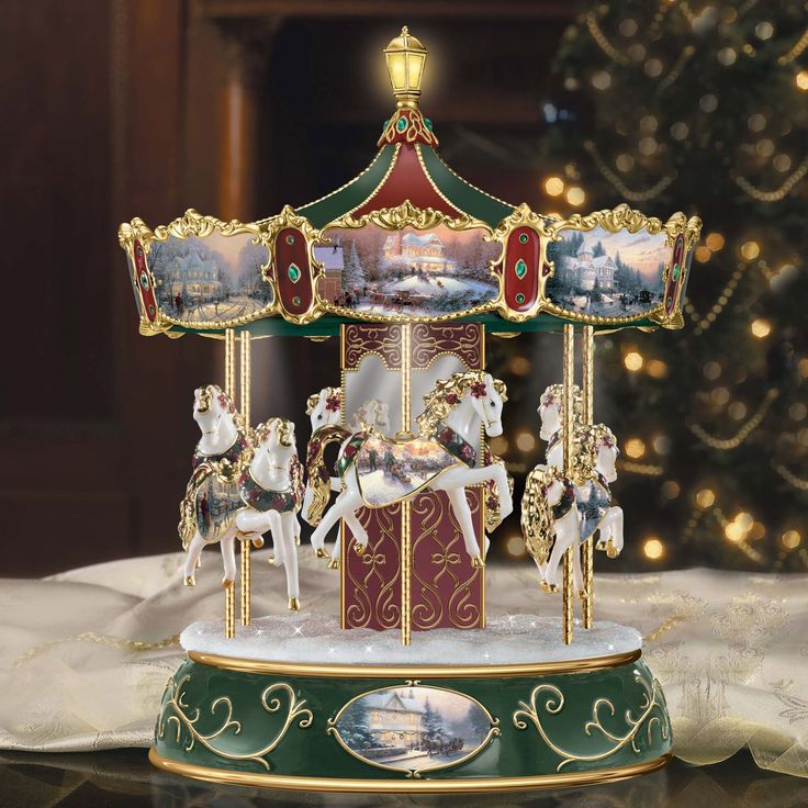 a merry go round carousel with horses on it's stand in front of a christmas tree