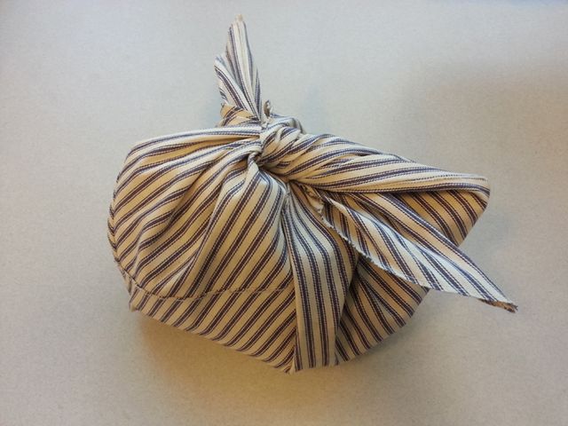 an origami ball with a bow on it sitting on top of a table