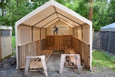 a wooden bench sitting under a white tent