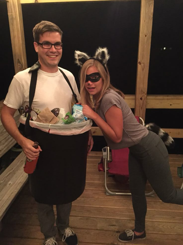 a man and woman pose for a photo while holding a tray with food on it