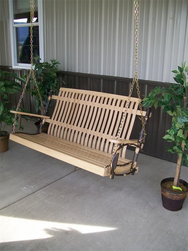 a wooden swing sitting next to a potted plant