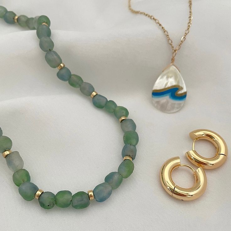 Searching for an iconic summer necklace? Look no further! Don't just take a dip in the sea. Dive in with our Ocean Eyes Necklace! Let these dreamy blue-green swirled recycled matte glass beads transport you to the depths of the ocean. Whether it's center stage or the base for layering, you'll fall in love with this versatile statement necklace. 7mm recycled glass beads, hand-made by the Krobo Tribe of Ghana, West Africa 4mm smooth roundel beads in 14kt gold or sterling silver. Adjustable chain l Green Ocean-inspired Necklaces For The Beach, Ocean-inspired Green Necklaces For Beach, Green Ocean-inspired Necklaces For Beach, Green Ocean-inspired Beach Necklaces, Ocean-inspired Green Jewelry For Vacation, Green Ocean-inspired Jewelry For Vacation, Green Strand Jewelry For Vacation, Adjustable Green Strand Necklace, Green Summer Jewelry For Everyday